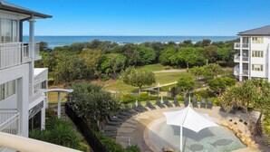 A hotel with a pool area, outdoor seating, and a view of the ocean. - The Pool Resort Kingscliff - One Bed Ocean View (2308) - Holiday Management Co. (Tweed)
