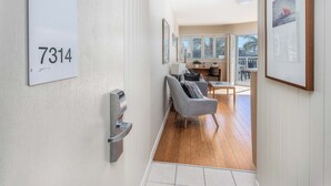 A modern interior with a number sign, a seating area, and a view to the outside. - The Pool Resort Kingscliff - 1 BR Spa Suite (7314) - Holiday Management Co. (Tweed)