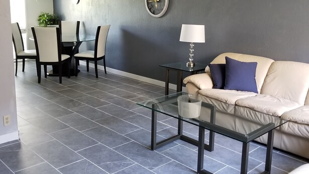 Una sala moderna con una mesa de centro de vidrio, un sofá y un comedor con sillas y una mesa.