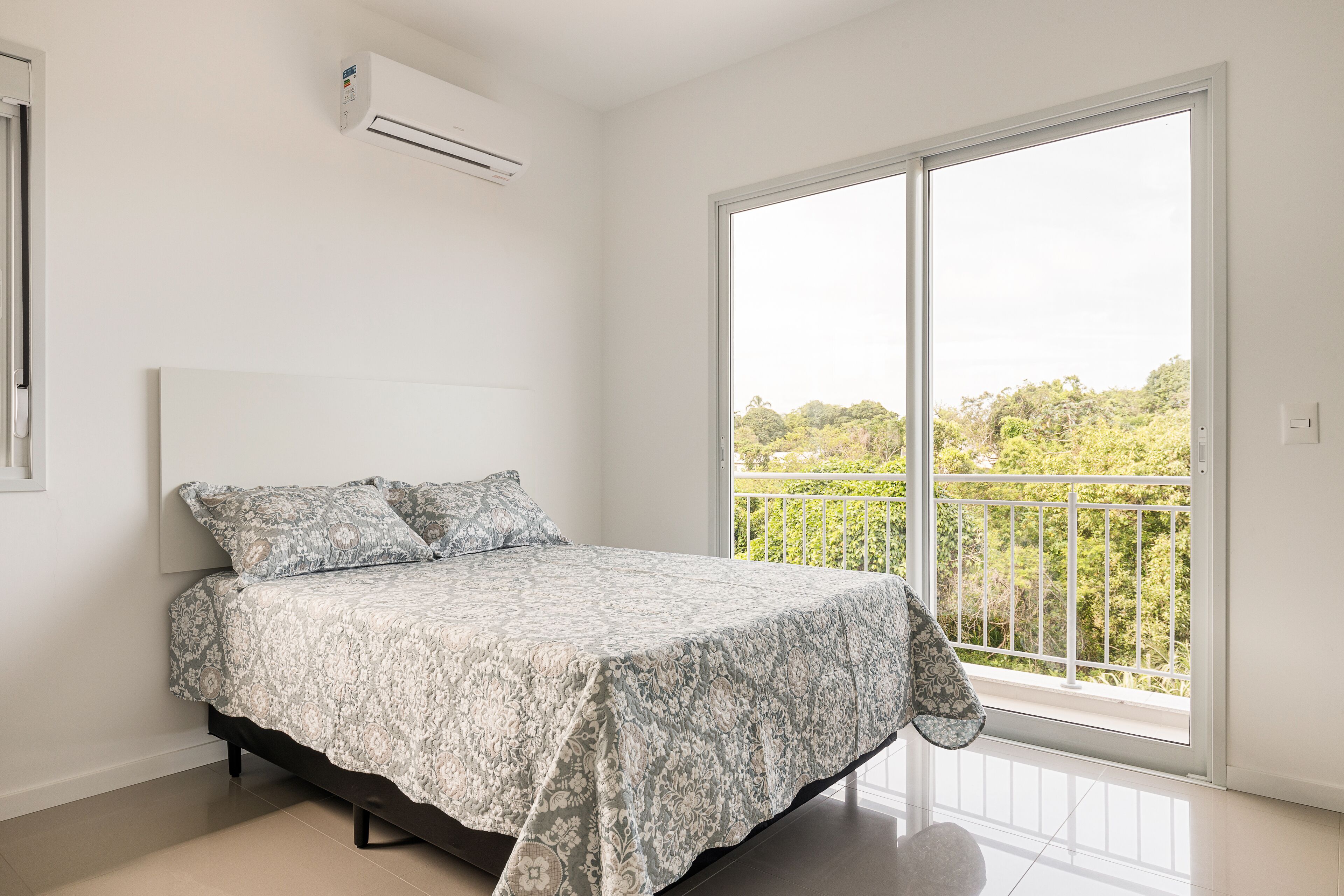 Une chambre à coucher avec un lit, une fenêtre et un balcon.
