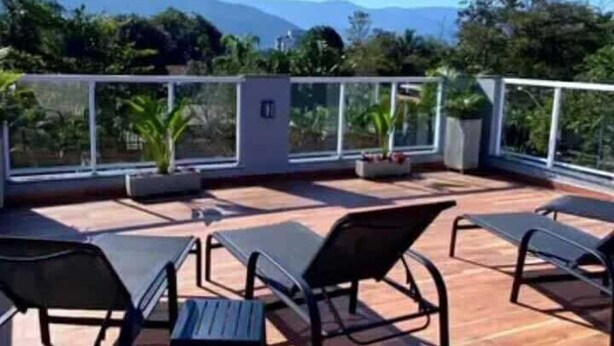 Terraço no telhado com área de estar ao ar livre e vista para montanhas.