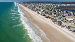 Vista aérea de uma área residencial costeira com casas ao longo da praia.