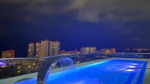 A rooftop pool with a city skyline in the background. - CONDO NAUTICO BY TRVL2HM (Puerto Vallarta)