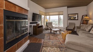 A cozy living room with a fireplace, comfortable seating, and a television. - Eolus 321 - Managed by Purgatory Result (Durango)