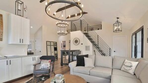 Un salon spacieux comprenant un canapé, une table basse et un escalier menant à l’étage supérieur.