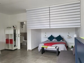 A bedroom with a bed, bedside tables, a wardrobe, and a built-in bench.