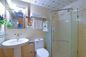 A bathroom with a glass shower enclosure, a white sink, and a toilet. - Yidun Hotel (Chongqing)