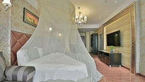 Un dormitorio con cama, sofá, televisión y armario.