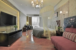 A bedroom with a bed, a TV, a sofa, and a desk. - Yidun Hotel (Chongqing)