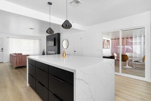 Enjoy a spacious living and dining area with a sleek island, flat-screen TV, and comfortable seating.