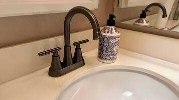 Un lavabo de bany amb un aixeta moderna i un dispensador de sabó decoratiu.