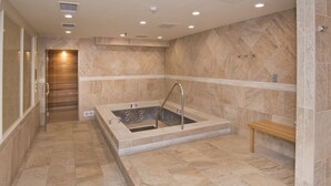 Un baño moderno con una bañera independiente, un banco y una zona de ducha.