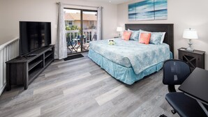 A bedroom with a bed, a TV, a desk, and a balcony with a view. - Beach Blossom Villa - Privacy and Perfect Location (Fort Walton Beach)