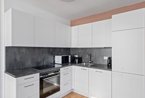 Prepare meals in this kitchen with oven, microwave, and sink.