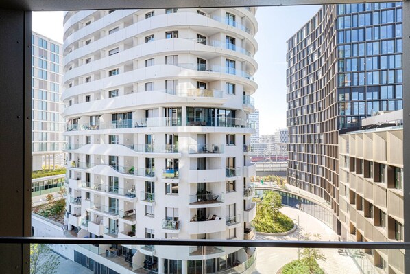 A multi-story residential building with balconies, large windows, and a modern architectural design.