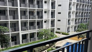 Un immeuble d’appartements moderne doté de balcons, d’une piscine et d’un espace jardin.