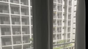 Une vue depuis un balcon, avec une piscine et un bâtiment en arrière-plan.