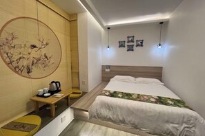 A compact hotel room with a bed, bedside table, and a wall-mounted artwork. - House 67, Yandang Mountain (Yueqing)