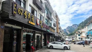 A street with multiple storefronts, including a hotel with a sign indicating room number 67.