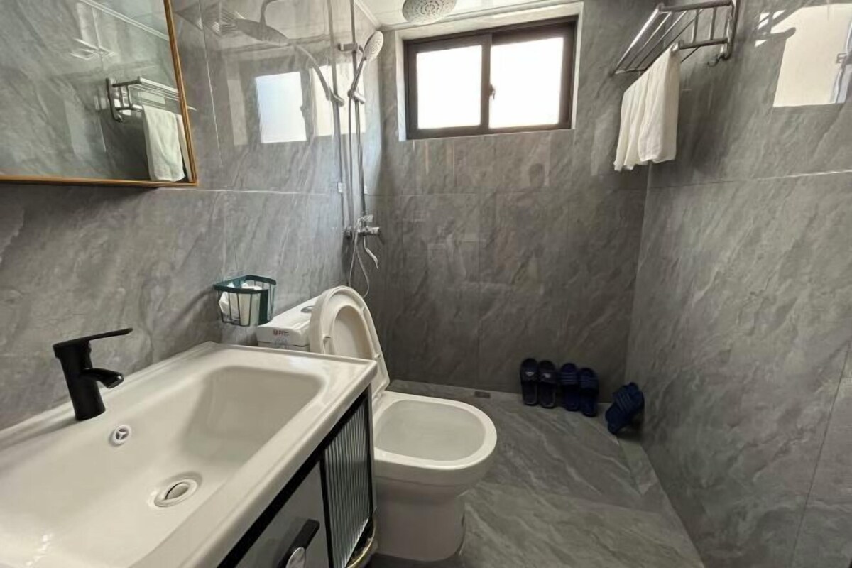 A modern bathroom with a bathtub, toilet, and shower.