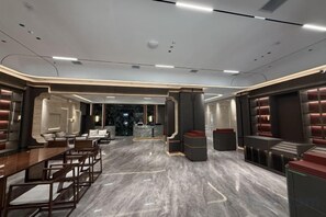 A spacious hotel lobby with a marble floor, seating areas, and a central column. - Long Cheng Hotel (Xiangxiang)