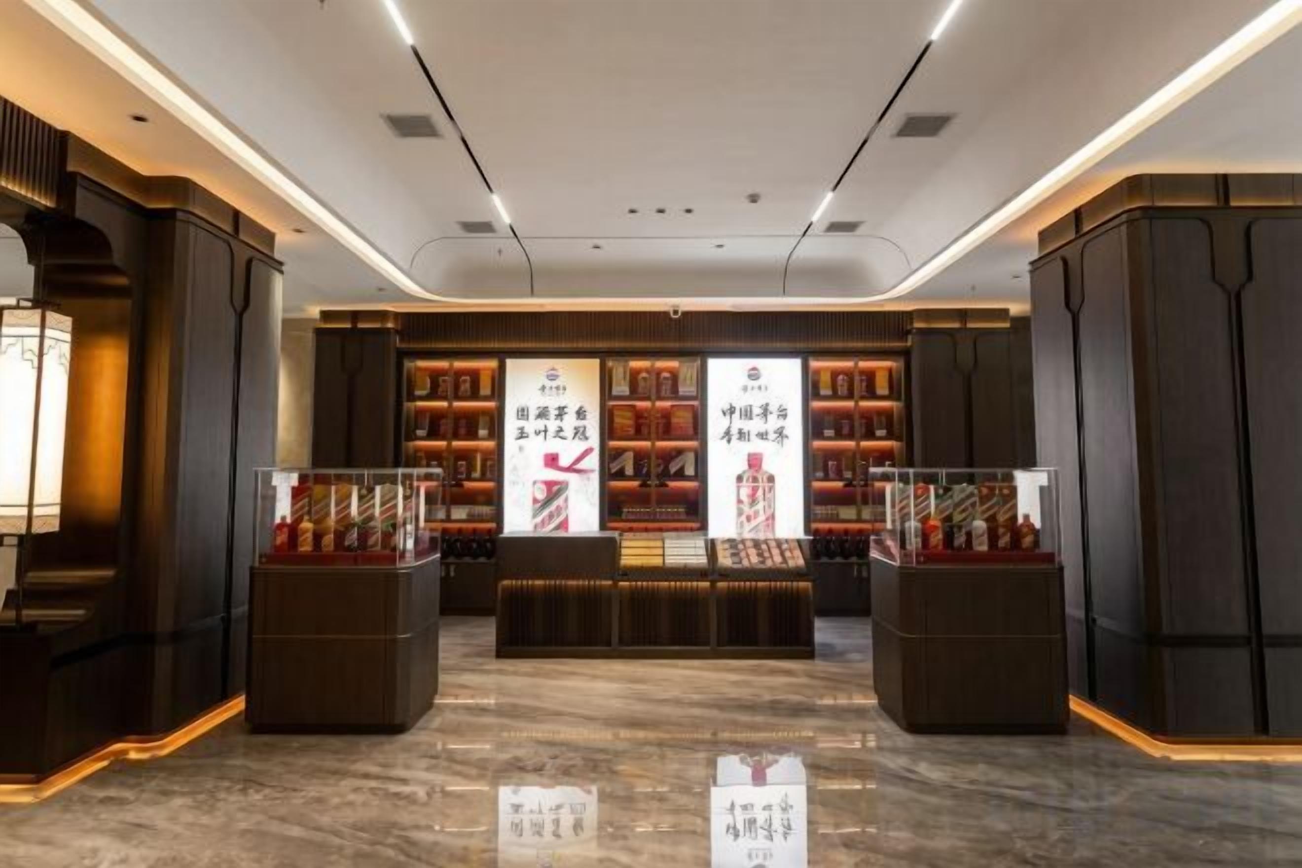 Interior moderno com área de exposição central, prateleiras com produtos e piso de mármore.