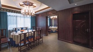 A dining area with a chandelier, wooden furniture, and a view into another room. - Long Cheng Hotel (Xiangxiang)