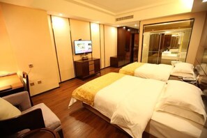 A hotel room with two beds, a television, a desk, and a mirror. - Donghu Hotel (Shouning)