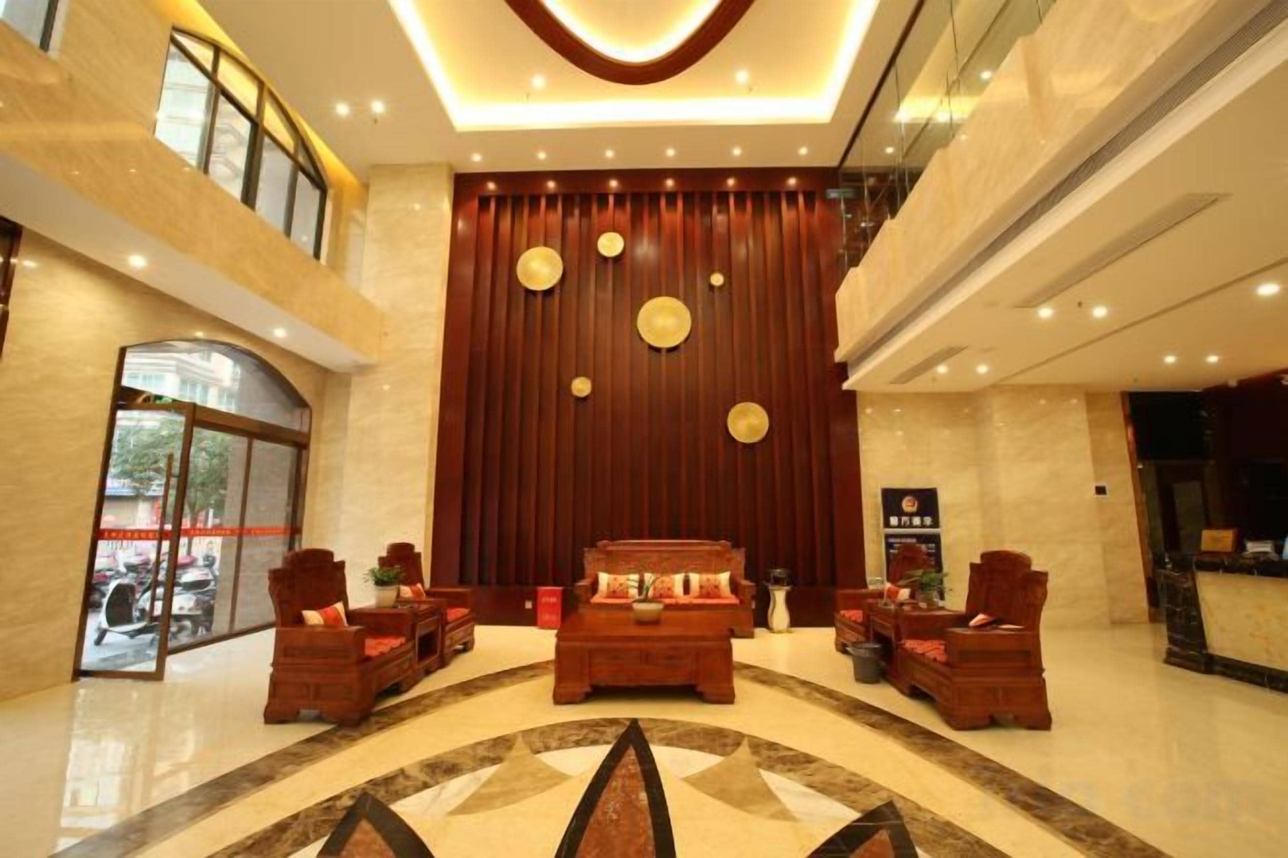 A lobby with a reception desk, seating area, and a large wall with circular decorations.