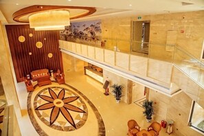 A hotel lobby with a central circular design, a reception desk, and a staircase leading to an upper level. - Donghu Hotel (Shouning)