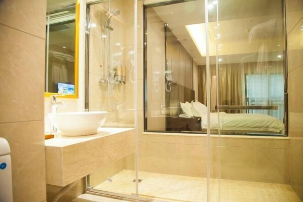 A modern bathroom with a glass-enclosed shower, a white sink, and a large mirror. - Donghu Hotel (Shouning)