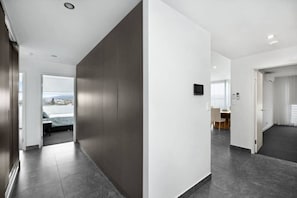 Experience a sleek and contemporary corridor with a flat-screen TV and comfortable seating area.