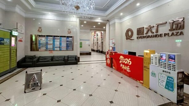 A hotel lobby with a chandelier, a reception desk, and a sign reading 'EverGrande Plaza.' - Shibadu Apartment (Guilin)