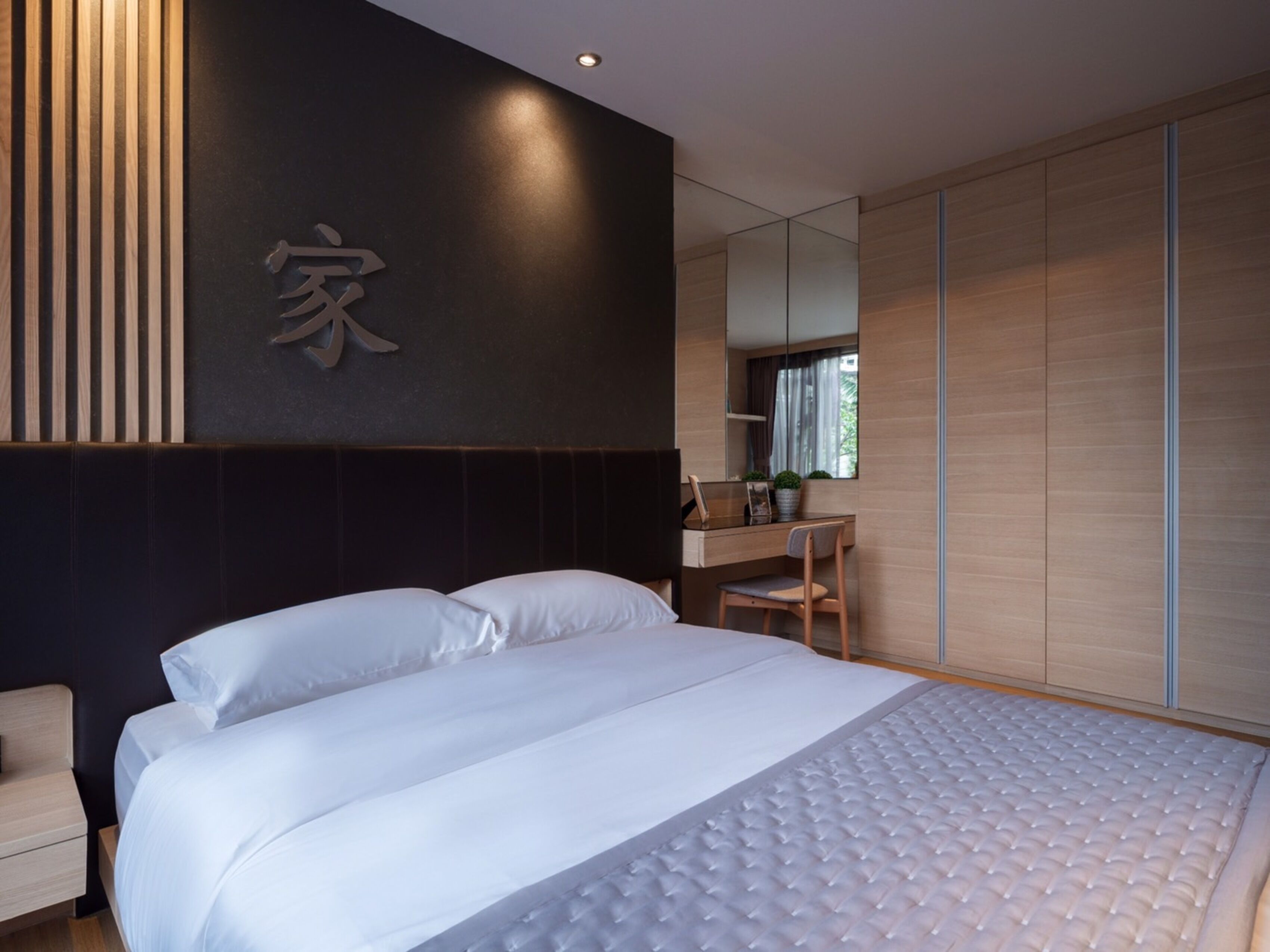 Un dormitorio moderno con una cama grande, un escritorio y un armario.
