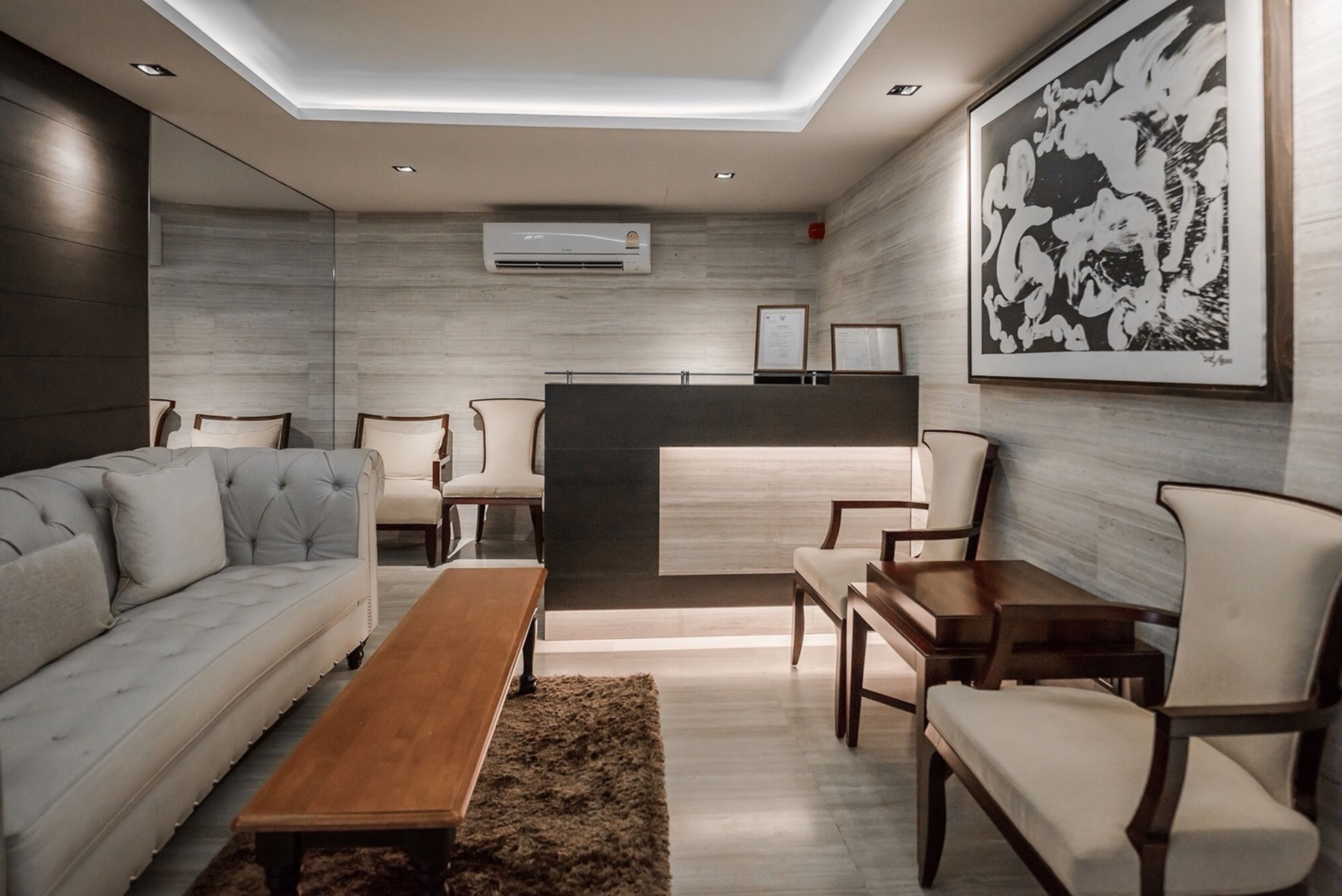 A modern living room with a sofa, chairs, a coffee table, and a dining area.