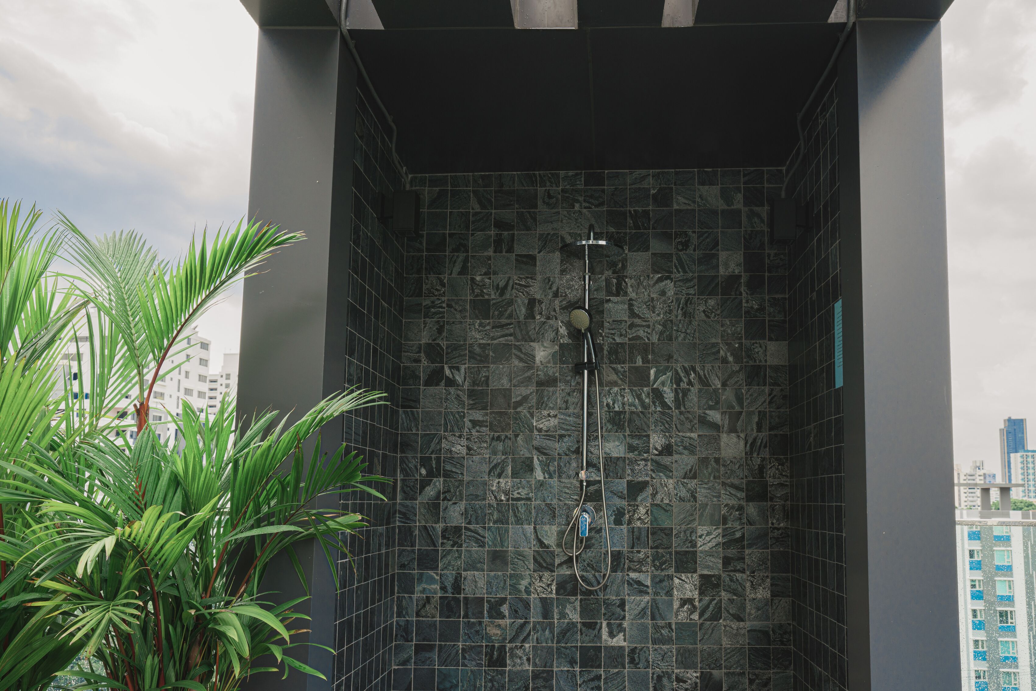 Eine moderne Dusche mit gefliestem Wandbereich und einer sichtbaren Duschbrause.