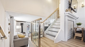 A modern interior with a staircase, a sofa, and a fireplace. - Welcome to Lake House On Park (Yarker)