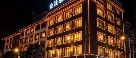 A multi-story hotel building with illuminated signage and windows.