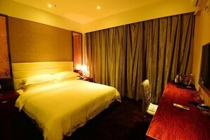 A hotel room with a bed, a desk, a chair, a television, and curtains. - Jin Ting Hotel (Shanglin)
