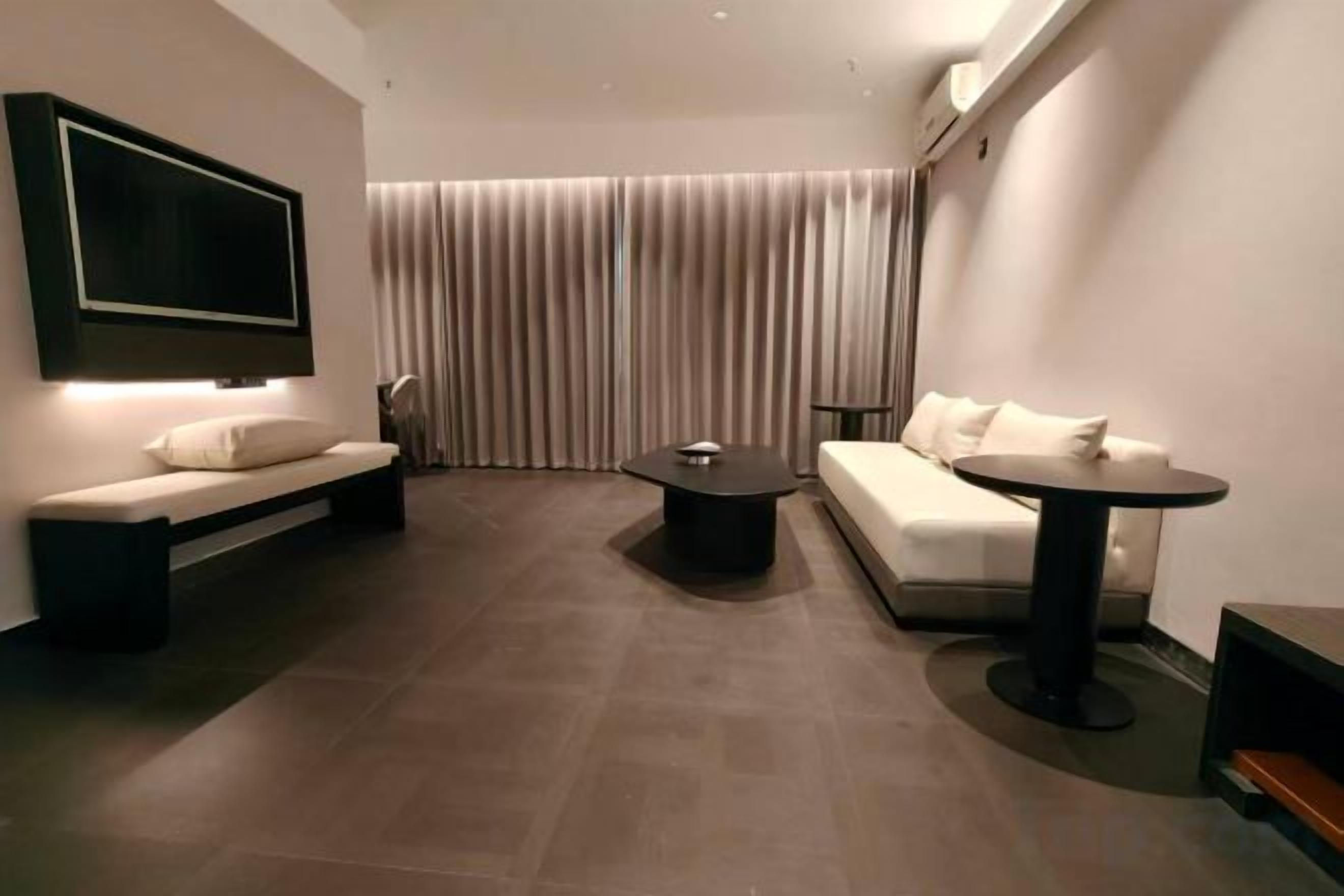 Un salon moderne avec un canapé, une table basse et un téléviseur fixé au mur.