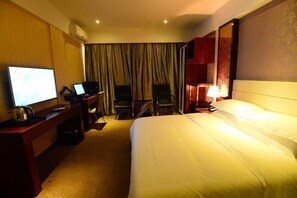 A hotel room with a bed, a desk with a laptop, a television, and a chair. - Jin Ting Hotel (Shanglin)