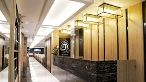 A hotel reception area with a modern design, featuring a marble reception desk, wooden paneling, and contemporary lighting fixtures. - D Loft Hotel (Kuala Lumpur)
