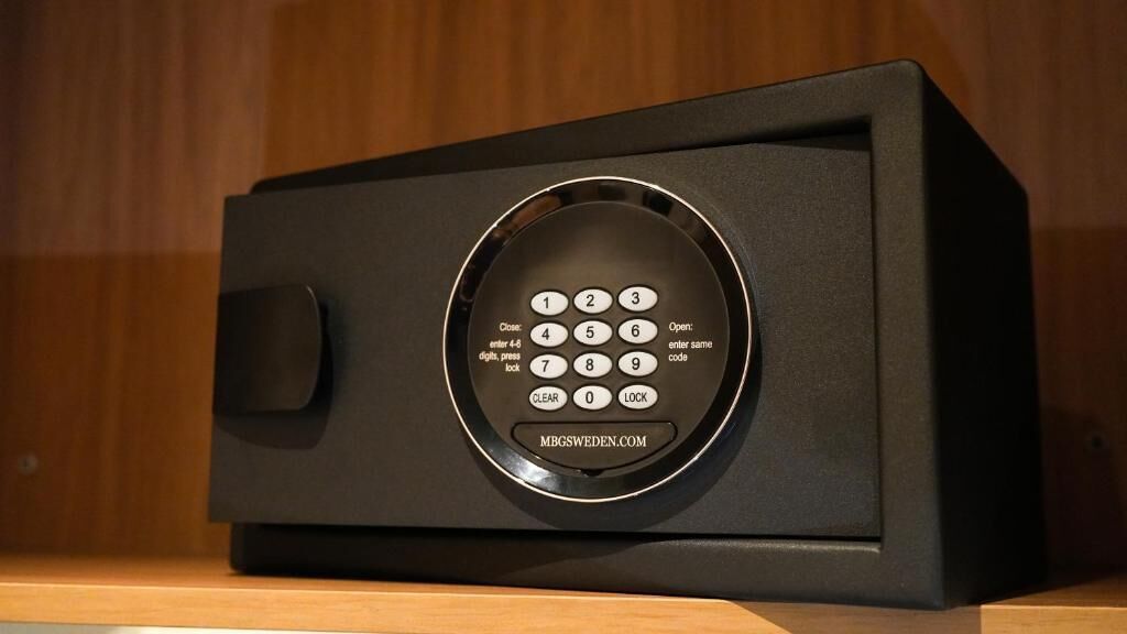 A black safe with a keypad and a handle on the left side.