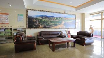 Eine großzügige Lobby mit einem großen Landschaftsgemälde, Ledersofas und einem Couchtisch.