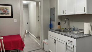 A compact kitchen with white cabinets, a granite countertop, and a small sink. - The Yellow-Shuttered House apt B (Sharon)