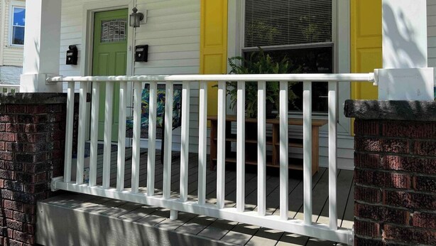 A porch with a white railing, a green door, and yellow trim. - The Yellow-Shuttered House apt B (Sharon)
