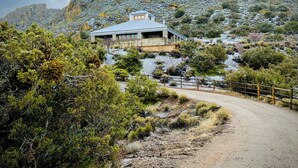 A modern house with a large window, surrounded by a natural landscape with rocky hills and sparse vegetation. - Spacious Artist Loft  in Tehachapi (Tehachapi)