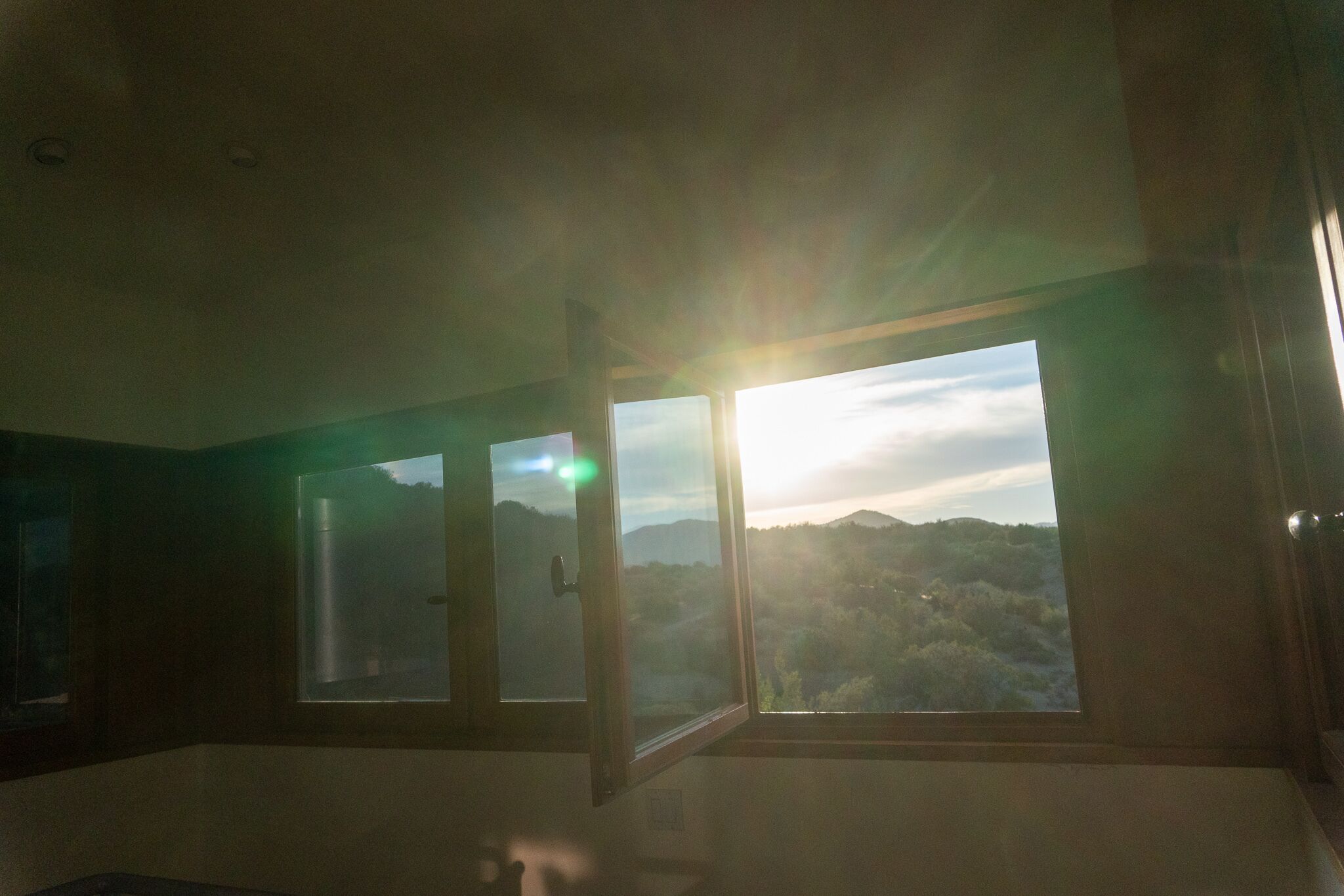 A room with large windows offering a view of a mountainous landscape.