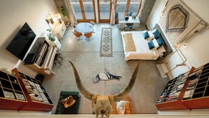 A spacious living area with a large window, a piano, a dining table, and a sofa. - Spacious Artist Loft  in Tehachapi (Tehachapi)