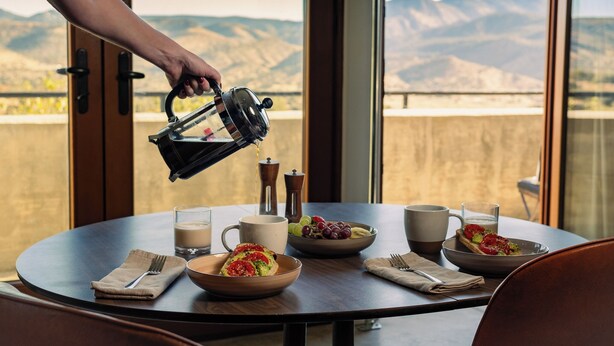 A breakfast table with a view of mountains, a coffee maker, and various breakfast items. - Spacious Artist Loft  in Tehachapi (Tehachapi)